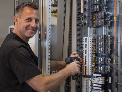 Tavletekniker udfører service på eltavle